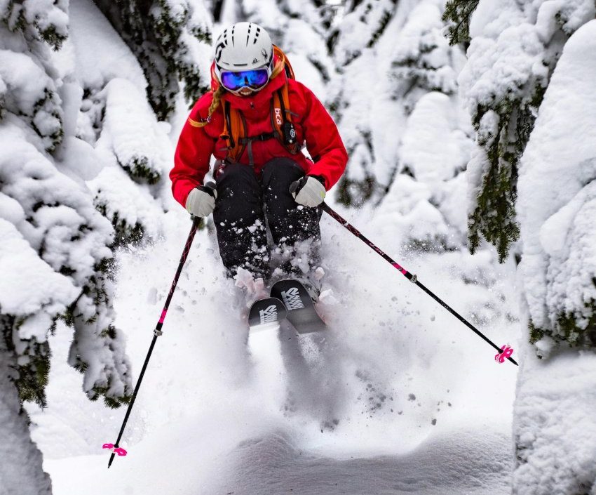Amie Engerbretson en backcountry dans la poudreuse entre forêt et barre rocheuse